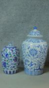 A large Oriental style blue and white lidded jar with stylized floral design along with a smaller