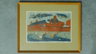 A mid century framed and glazed lino/woodblock print of a bridge across a river with brick houses in