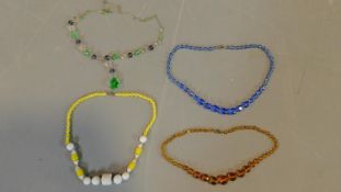 A collection of vintage Czech glass necklaces including an opaque yellow and white glass necklace, a
