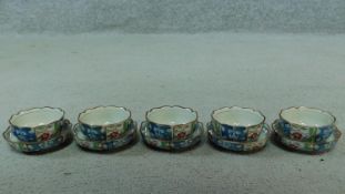 A wooden boxed set of five Oriental tea bowls and saucers with a floral design. Artist's signature