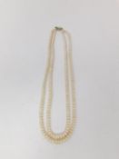 A double stranded vintage cultured pearl necklace with white metal push barrel clasp. Longest strand