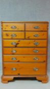A Victorian style pitch pine tallboy chest with an arrangement of eight drawers on bracket feet. H.