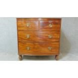 A Regency mahogany bowfronted chest of drawers on turned bun feet. H.92 W.93 D.56cm