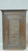 An antique country oak corner cupboard with foliate carved central panel door. H.86 W.59 D.35cm