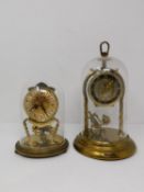 Two vintage German brass dome cased table clocks. One by Kundo with a plastic dome and twisted