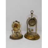 Two vintage German brass dome cased table clocks. One by Kundo with a plastic dome and twisted