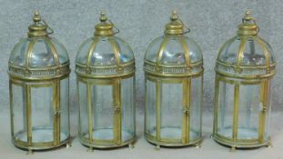 A set of four gilt metal framed hanging storm lanterns. H.48cm