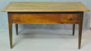 An antique country fruitwood dining table with cleated and planked lift up top above base fitted