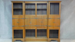 An oak three section library bookcase with open shelved sections and four pairs of central panel