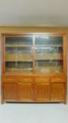 A large Eastern teak library bookcase with glazed sliding doors to the upper section above base