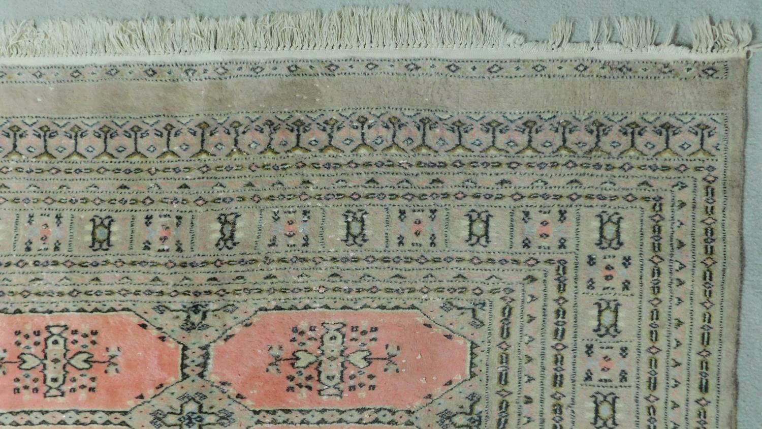 A woollen Bokhara style carpet with repeating lozenge motifs on rouge ground contained within - Image 3 of 4