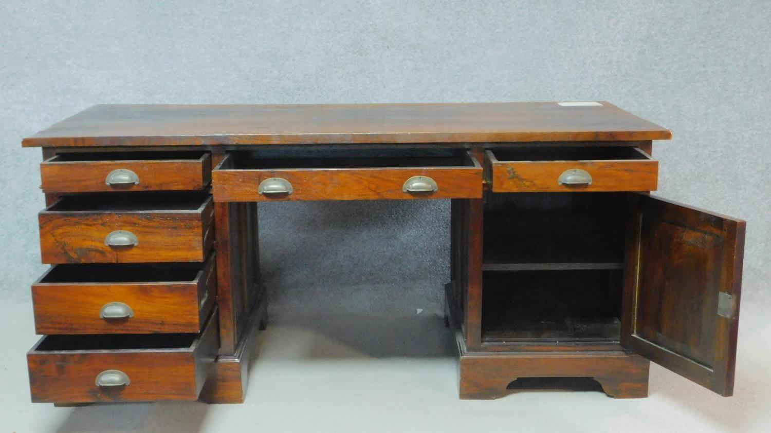 An Eastern teak three part pedestal desk fitted with a cupboard and drawers on bracket feet. H.78 - Image 2 of 5