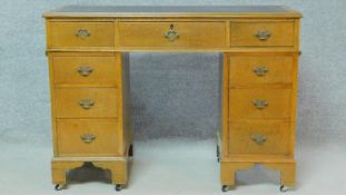 A Georgian style oak three section pedestal desk of narrow proportions with an arrangement of nine