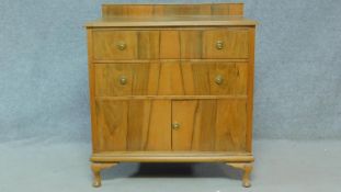 A mid 20th century figured walnut chest of two drawers above a pair of panel doors. H.100 W.92 D.