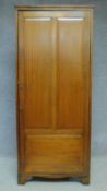 A vintage teak hall cupboard with panel door enclosing shelves on bracket feet. H.176 W.76 D.51cm