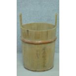A 20th century double handled wooden rice bucket with written Oriental characters. H.62cm