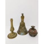 An antique brass bell along with an Indian elephant bell and brass repousse candle stick base. The