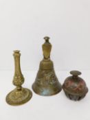 An antique brass bell along with an Indian elephant bell and brass repousse candle stick base. The