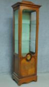 A Continental style walnut display cabinet with painted floral panel door enclosing glass shelves