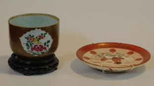 A 19th century Batavian porcelain bowl with floral design sitting on carved pierced wooden base,