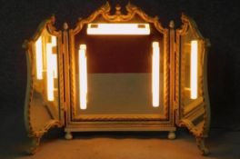 A mid century cream and gilt Rococo style triptych dressing mirror with later wired vanity lighting.