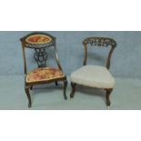 An Edwardian mahogany nursing chair with rouge floral upholstery and carved back on cabriole