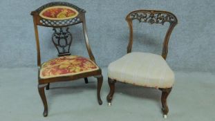 An Edwardian mahogany nursing chair with rouge floral upholstery and carved back on cabriole