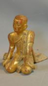 An early 20th century South East Asian lacquered carved gilt wood seated statue of the Monk