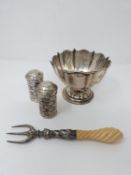 A pair of geometric pierced silver salt and pepper shakers with other items. The salt and pepper