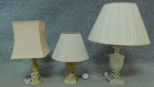 A vintage onyx urn shaped table lamp with shade and two other similar lamps. H.63cm (tallest)