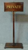 A vintage oak and brass visitors notice on platform base. H.140 W.59 D.33cm