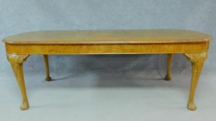 A mid century burr walnut Georgian style extending dining table on carved cabriole supports. (