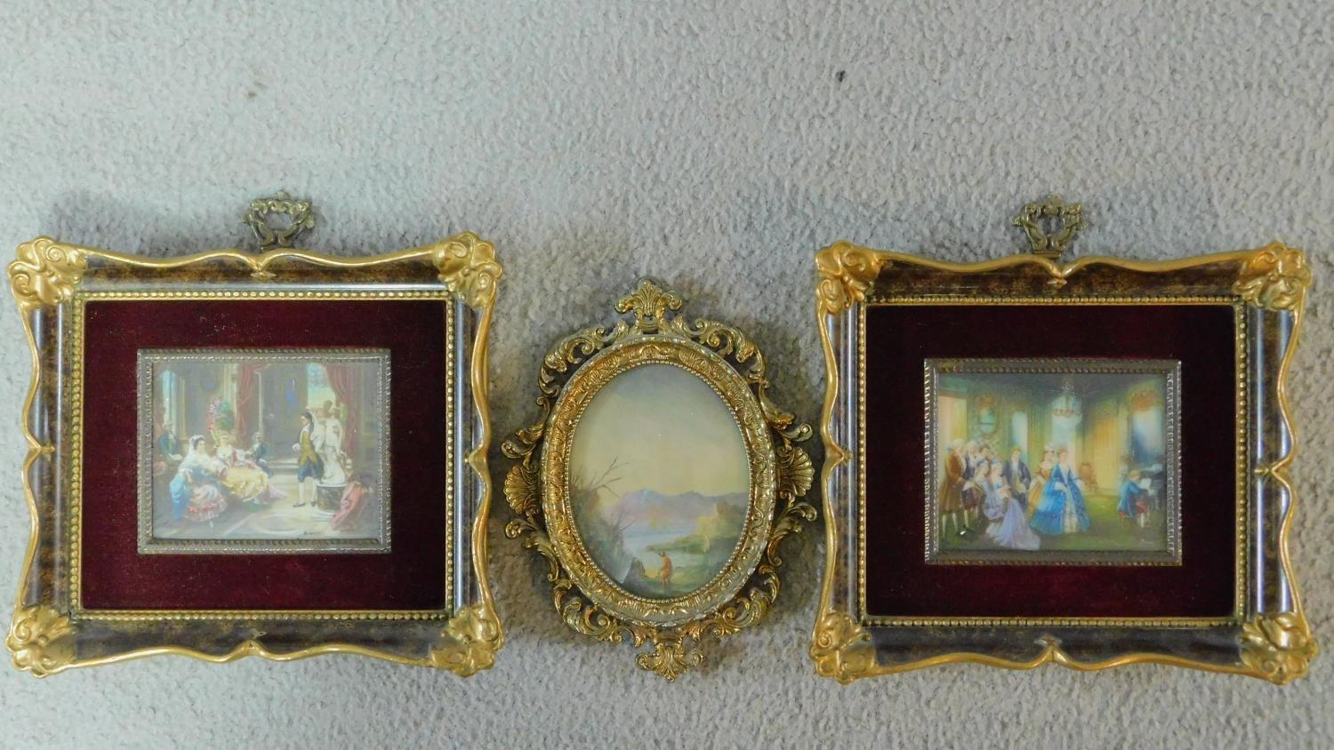 A pair of miniature prints, interior scenes and an oval landscape scene, all in decorative gilt