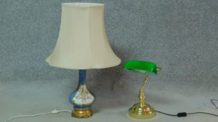 A green glass and brass bankers desk lamp along with a hand painted and gilded porcelain floral