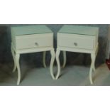 A pair of contemporary white lacquered bedside cabinets with plate glass tops above frieze drawers