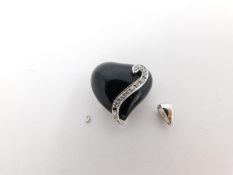 A 14 carat white gold onyx and diamond heart pendant.The bale has broken. The pedant is set with