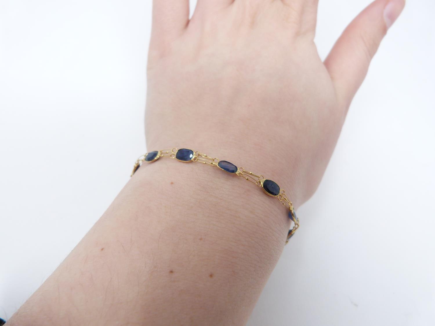 A bespoke heated ceylon sapphire and yellow metal (tested 14 carat yellow gold) chain bracelet, - Image 2 of 8