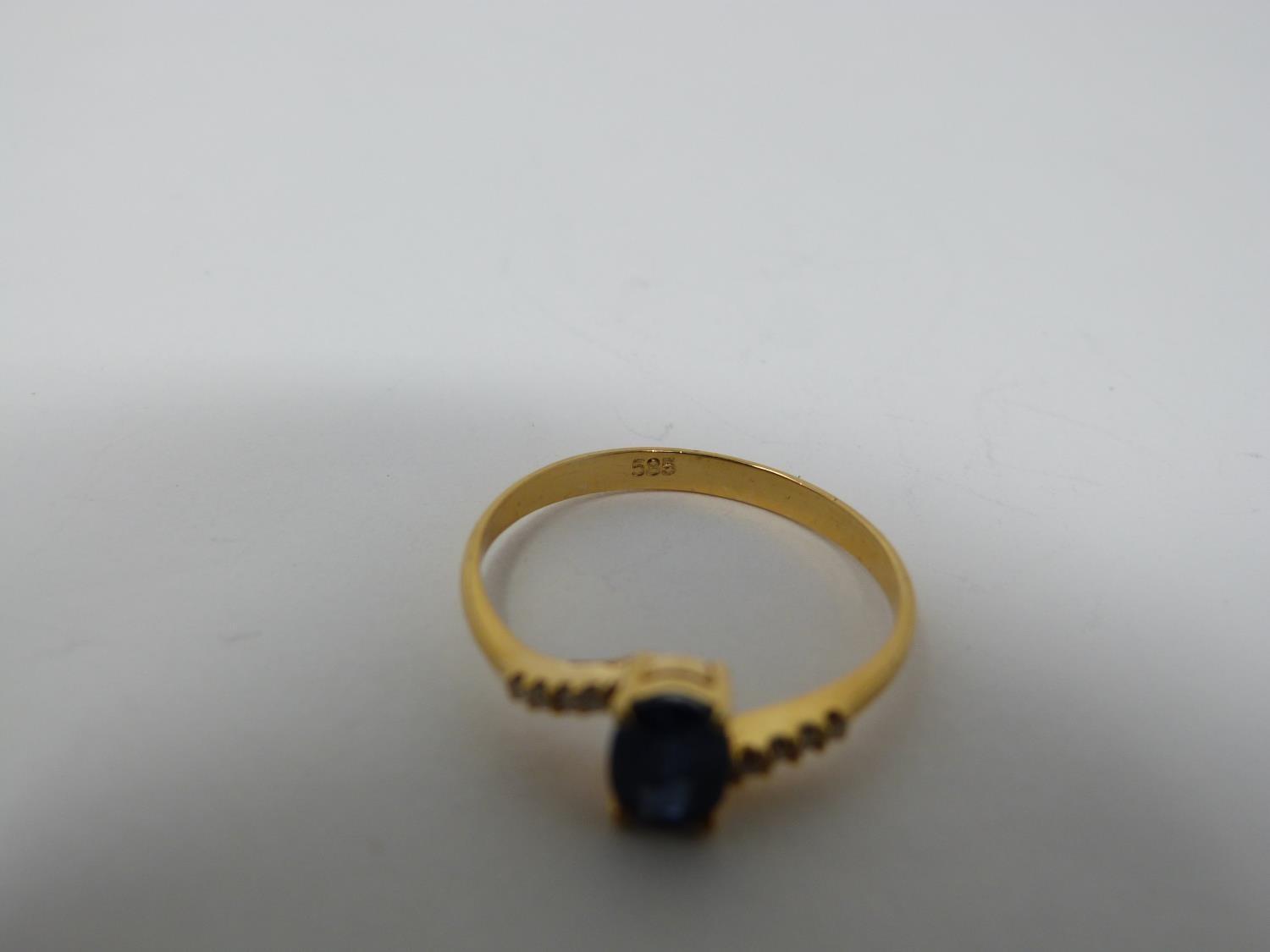 A heated Ceylon sapphire and diamond flanked solitaire 14 carat gold ring. Set with a central oval - Image 3 of 7