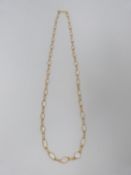 A bespoke yellow metal (tested 14 carat yellow gold) and moonstone chain necklace. Set with thirty