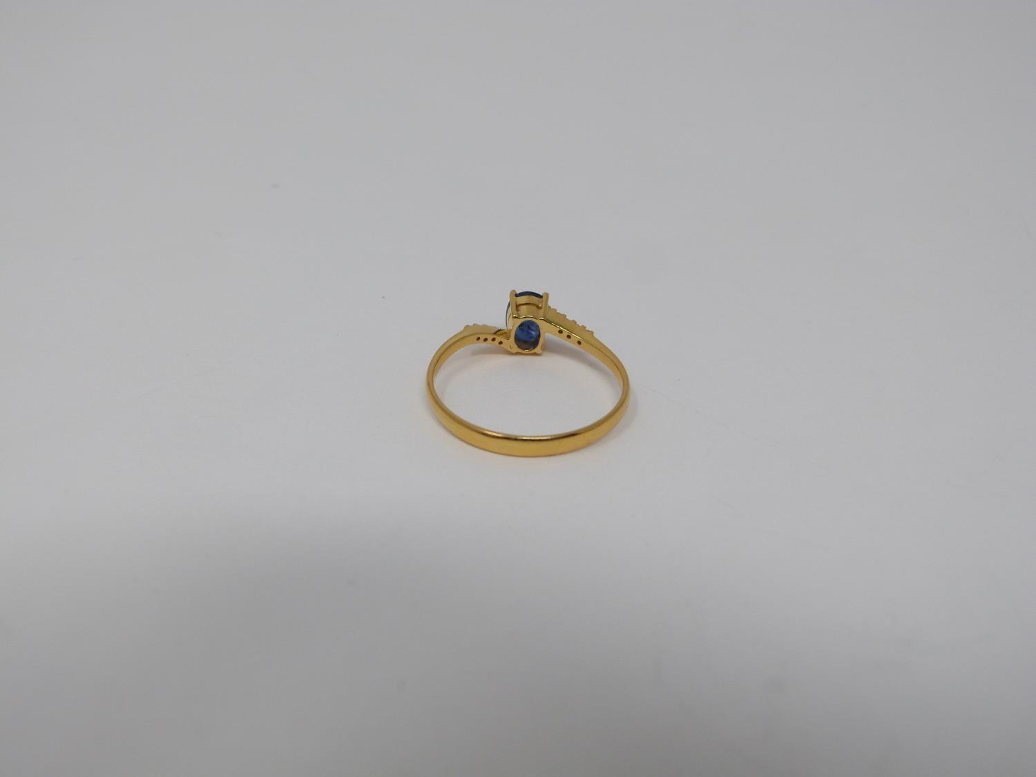 A heated Ceylon sapphire and diamond flanked solitaire 14 carat gold ring. Set with a central oval - Image 2 of 7