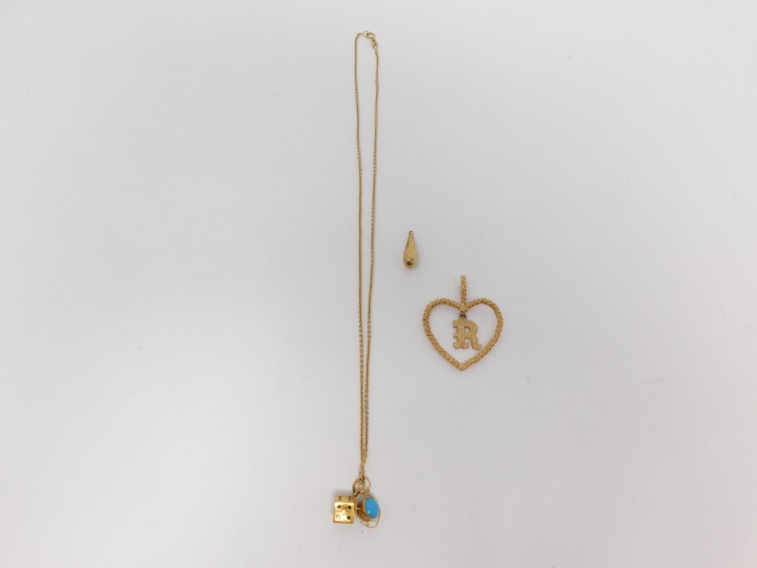 A 9carat gold chain with yellow metal dice charm and three 9 carat gold pendants. One pendant