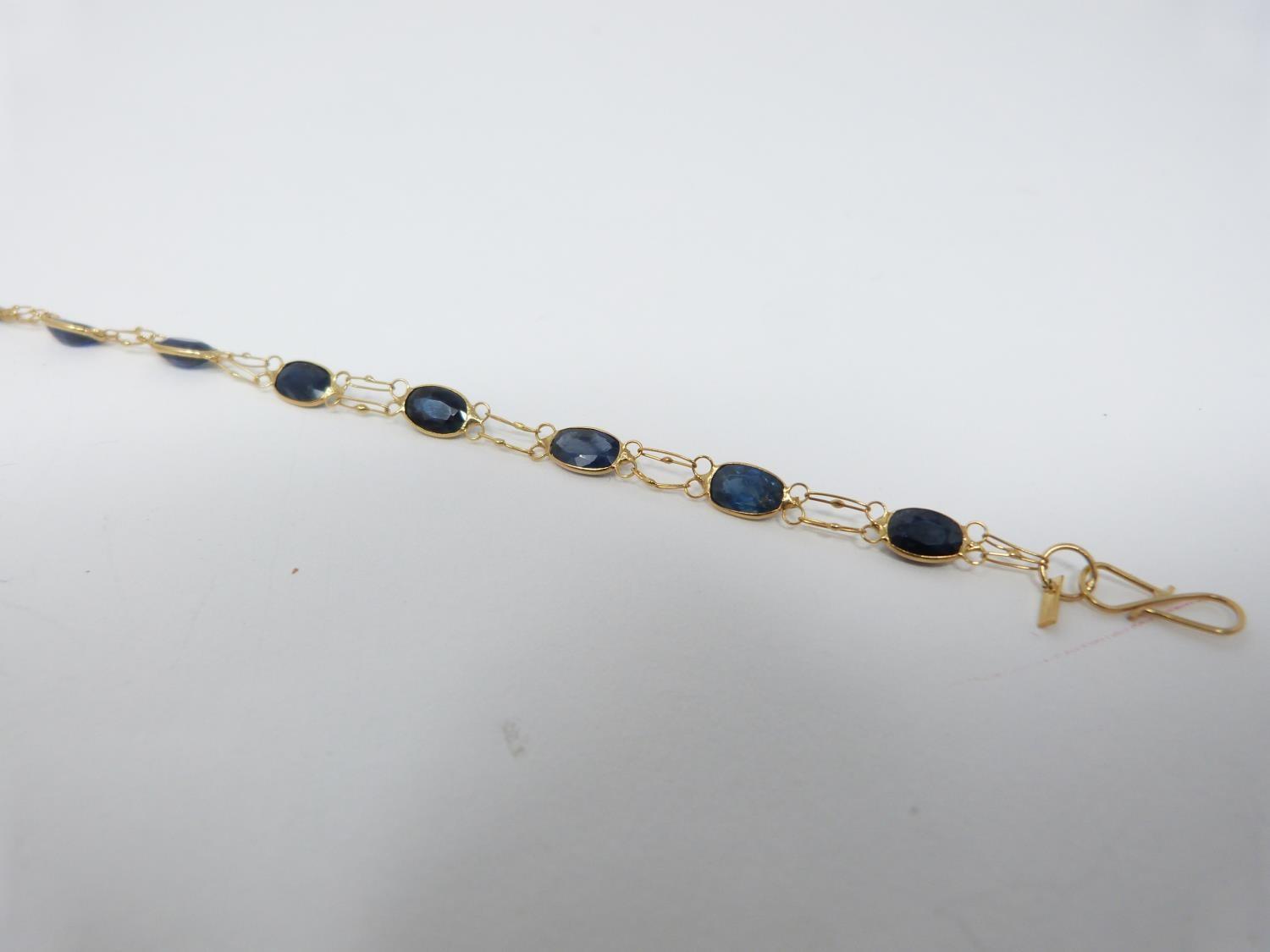 A bespoke heated ceylon sapphire and yellow metal (tested 14 carat yellow gold) chain bracelet,