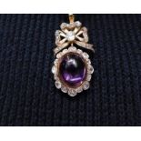 A victorian Amethyst and diamond pendant. Set with an oval amethyst cabochon with an approximate