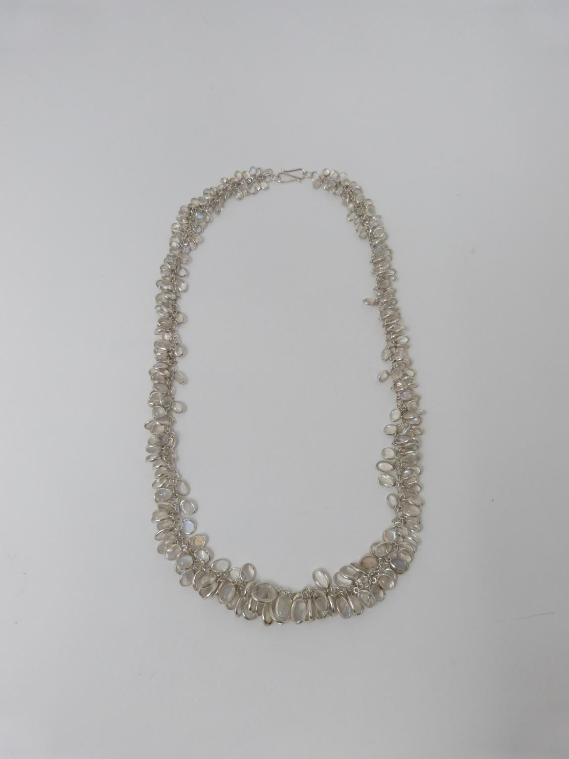 A bespoke Moonstone and silver graduated garland necklace. The oval moonstones set in individual