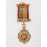 A 9 ct rose gold and enamel engraved Masonic lodge 1423 medal on an embroidered silk ribbon.