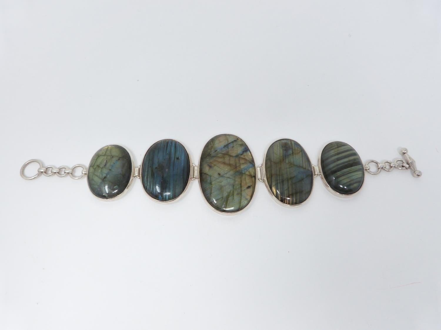 A bespoke silver and Labradorite articulated bracelet, set with five Labradorite cabochons,