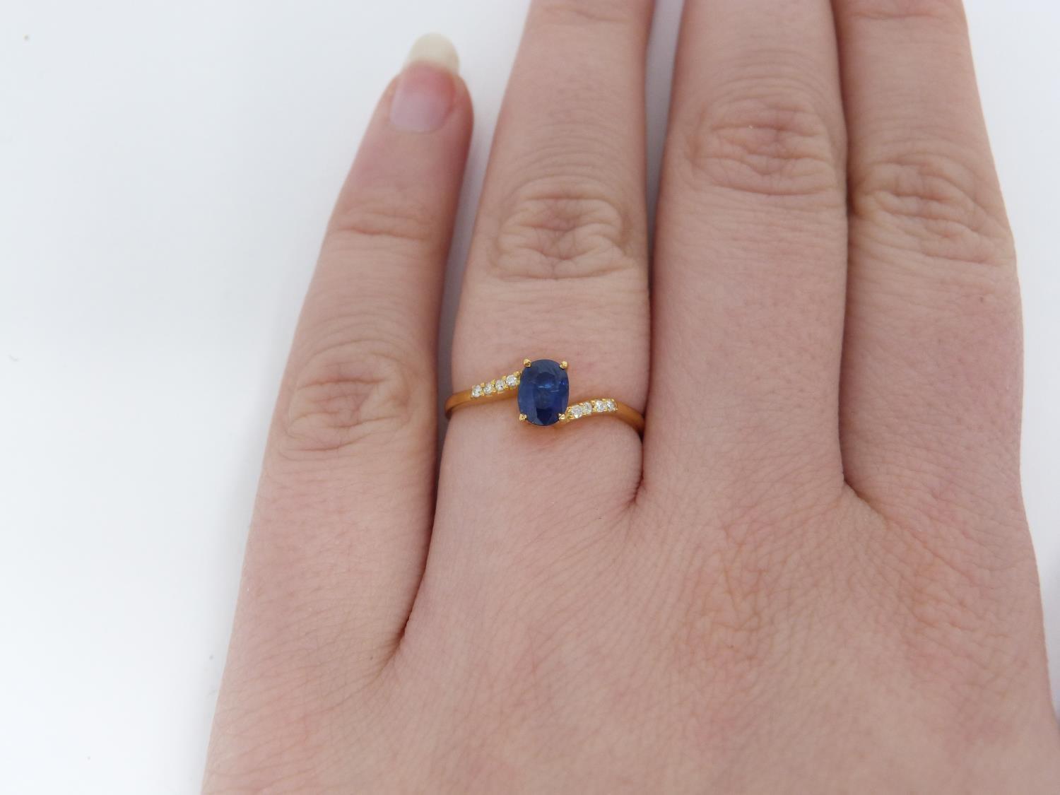 A heated Ceylon sapphire and diamond flanked solitaire 14 carat gold ring. Set with a central oval - Image 7 of 7