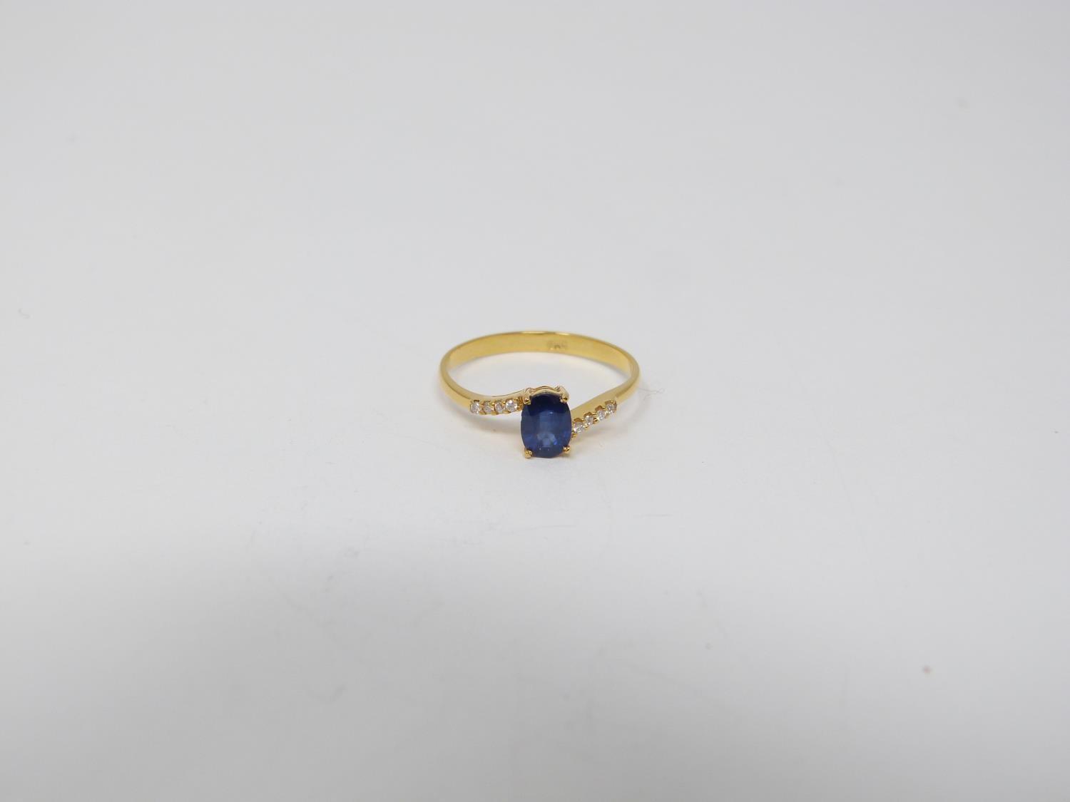 A heated Ceylon sapphire and diamond flanked solitaire 14 carat gold ring. Set with a central oval