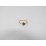 A heated Ceylon sapphire and diamond flanked solitaire 14 carat gold ring. Set with a central oval