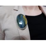 A bespoke Hawks Eye (possibly Pietersite) cabochon and white metal (tested silver) statement brooch,